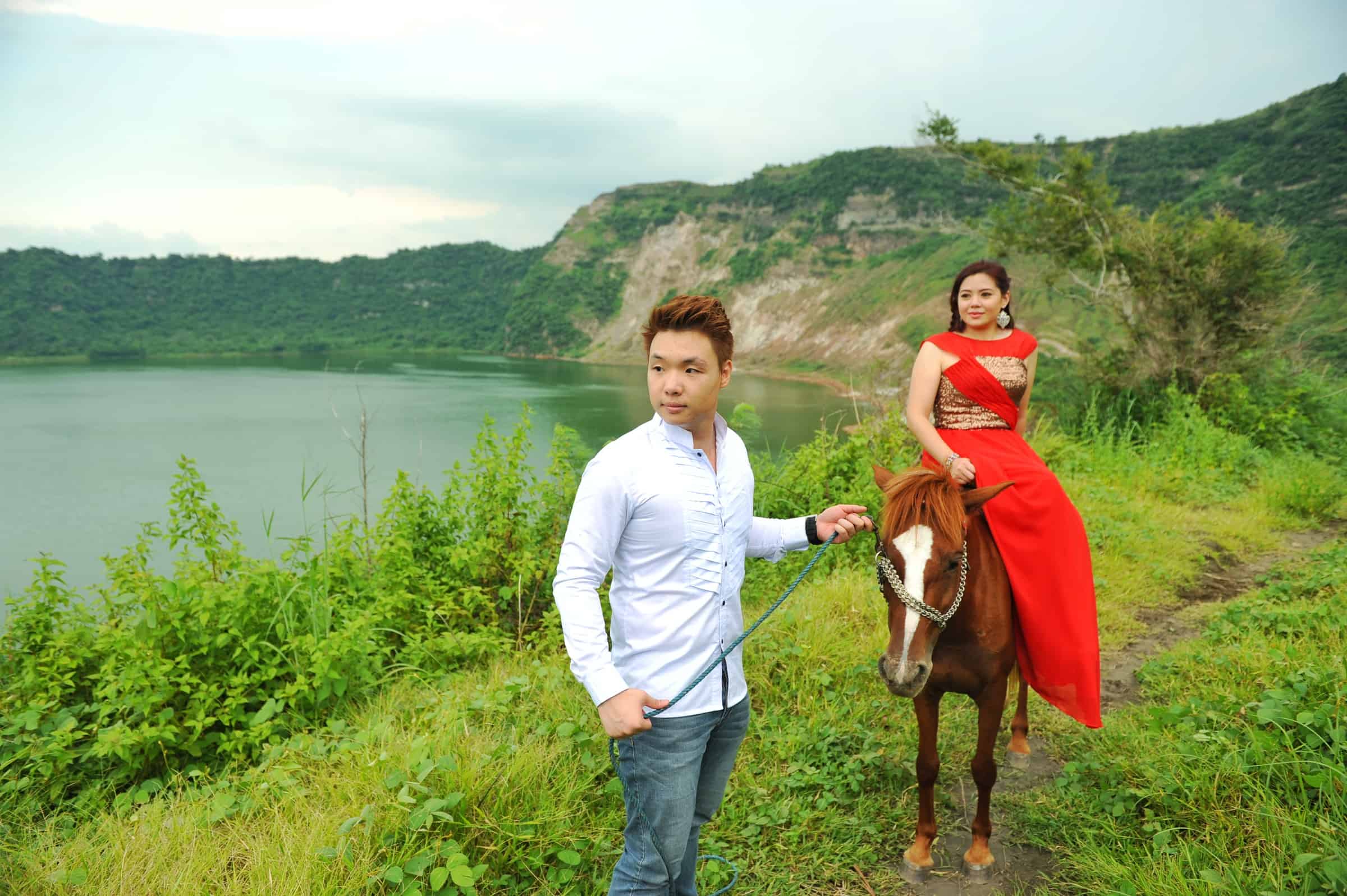 A couple in Taal Lake with a brown horse.
