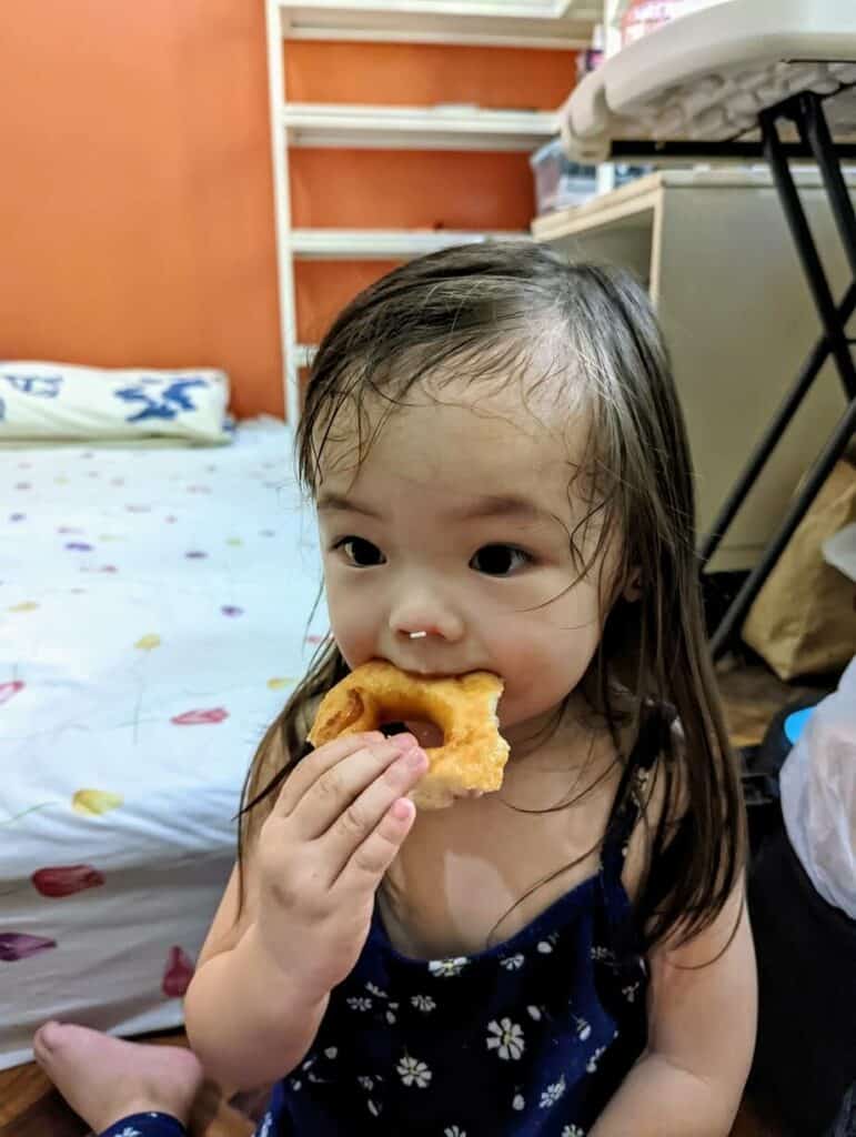 Little girl eating doughnut.