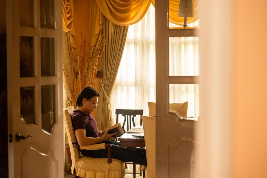 Working online can be lonely. Man reading book.