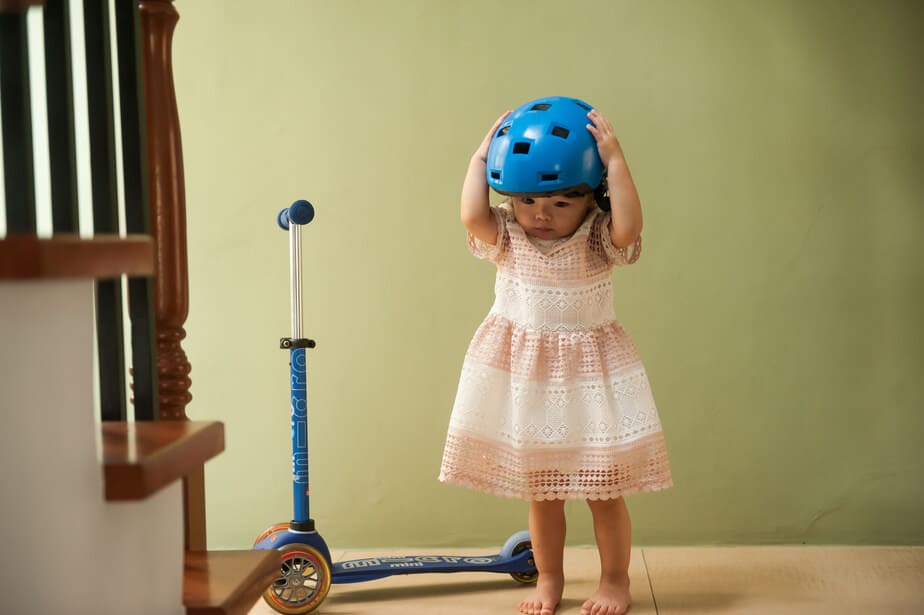 Girl with a scooter wearing helmet