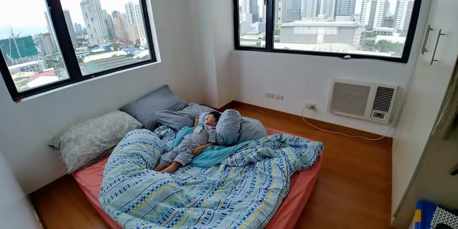 Boy sleeping alone in bed room.