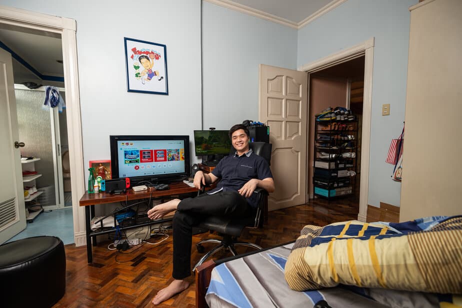 Man posing in front of TV and computers.
