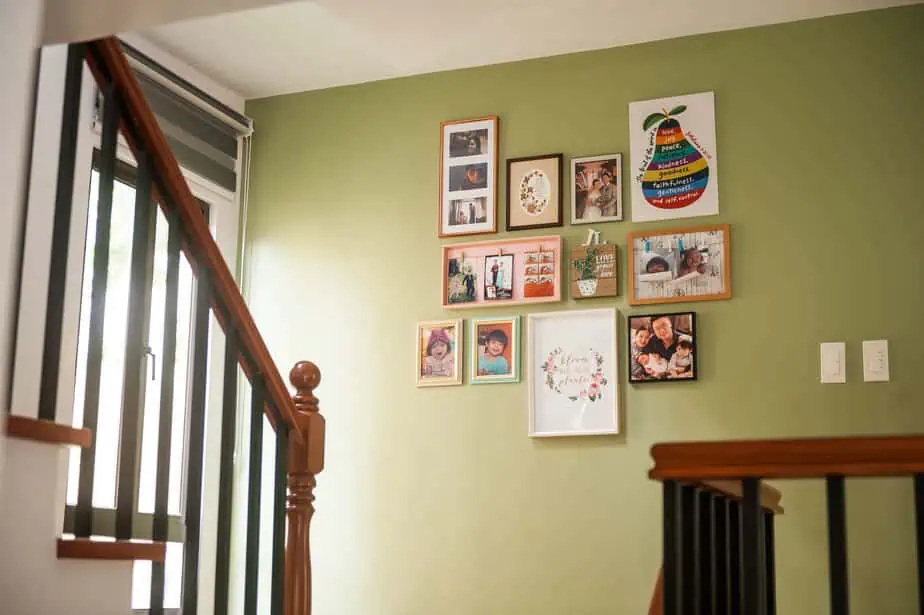 A collage of family photos on an olive green wall.