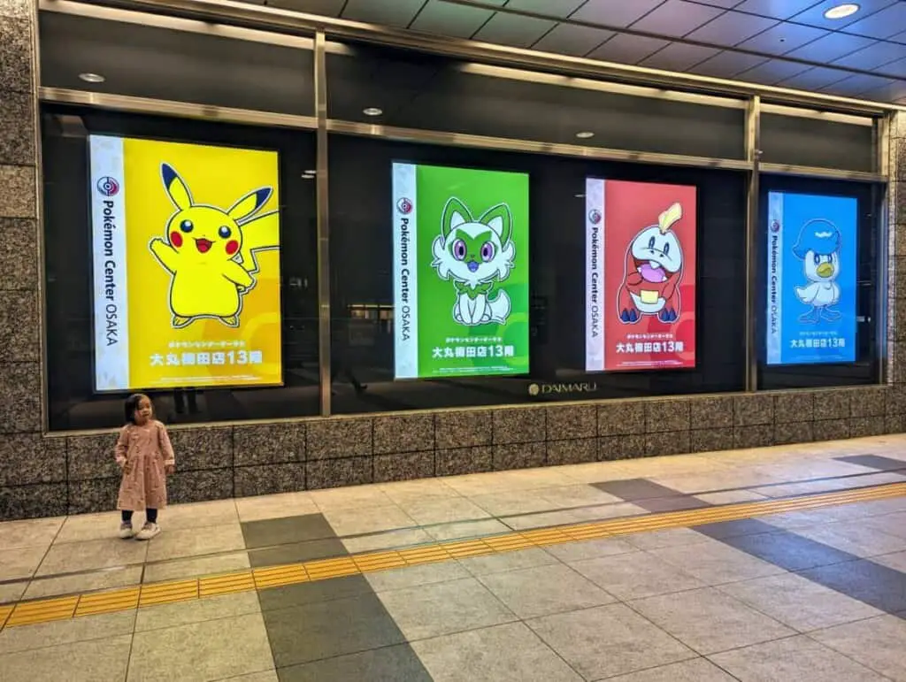 A girl taking a photo with Pokemon characters.
