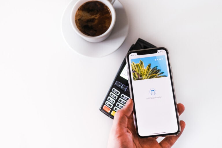 A digital banking app on a smartphone placed next to a steaming cup of coffee.